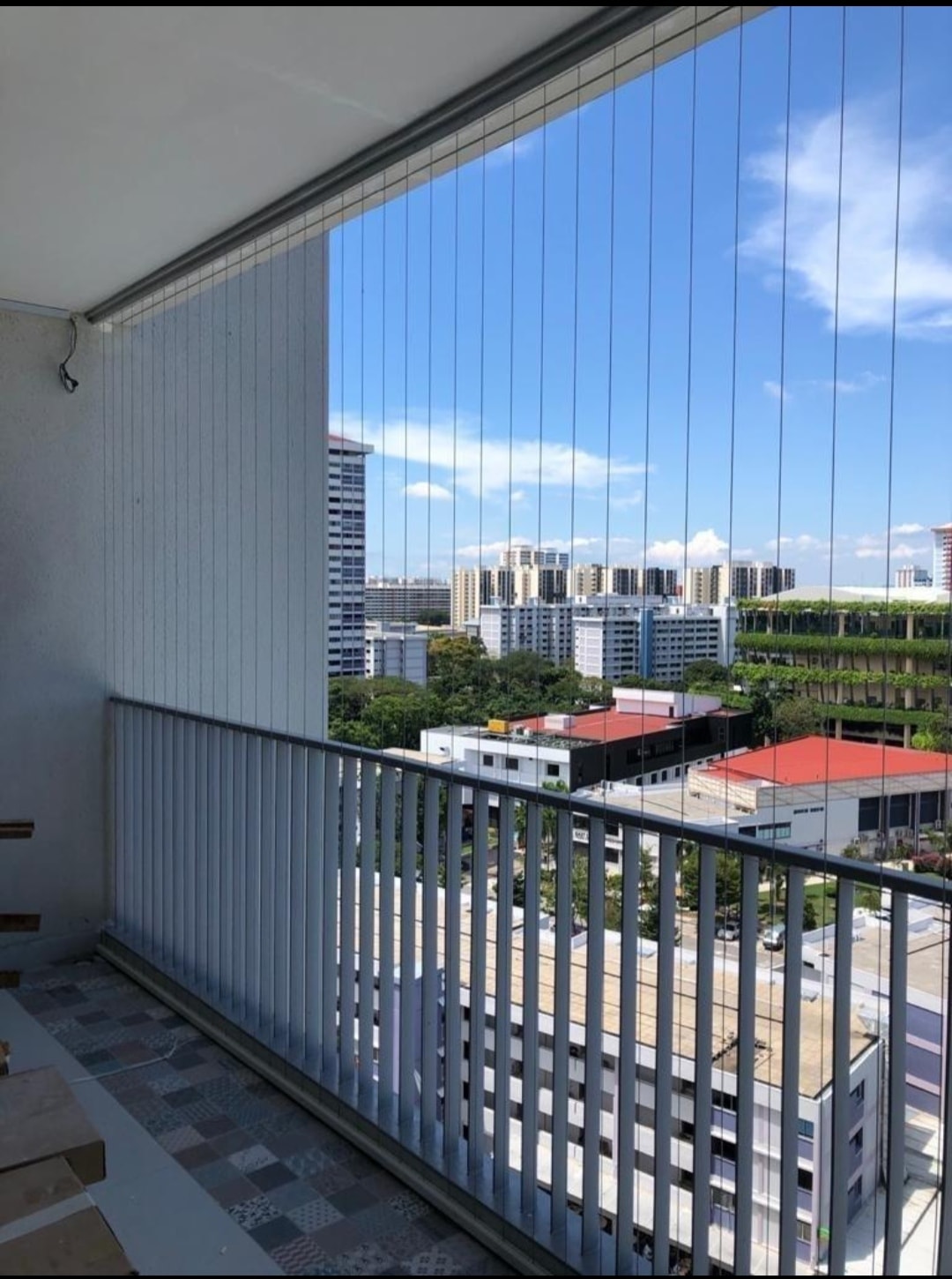 Nishitha invisible grill installation on high-rise apartment balcony with city view